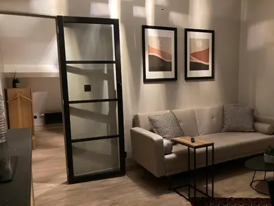 a living room with a couch and a mirror at Chez Roya in Zaventem