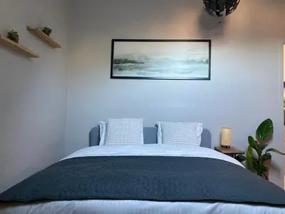 a bedroom with a bed with a picture on the wall at Chez Roya in Zaventem