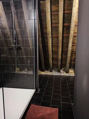 a bathroom with a shower and a tiled floor at Rooftop apartment with 60m terrace overlooking the cathedral in Antwerp