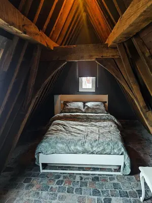 a bedroom with a bed in a attic at Rooftop apartment with 60m terrace overlooking the cathedral in Antwerp