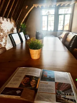 a magazine sitting on top of a wooden table at Rooftop apartment with 60m terrace overlooking the cathedral in Antwerp