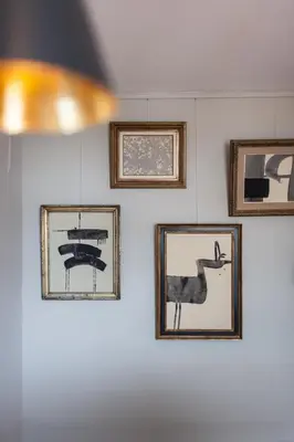 a group of framed pictures on a wall at B&B Louis1924 in Dilbeek
