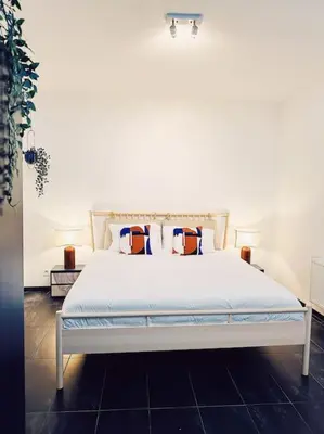 a bedroom with a white bed with two pillows at Historic Center Apartment Walk to Everything in Ghent