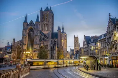 a large cathedral with a train in front of it at Historic Center Apartment Walk to Everything in Ghent