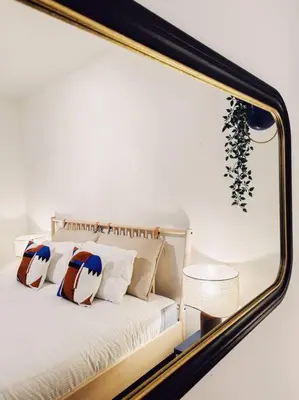 a mirror reflecting a bed with pillows on it at Historic Center Apartment Walk to Everything in Ghent