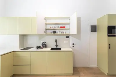 a kitchen with white cabinets and a white refrigerator at Beautiful studio in Antwerp