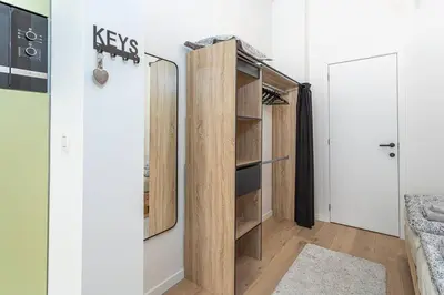 a bedroom with a closet with wooden shelves at Beautiful studio in Antwerp