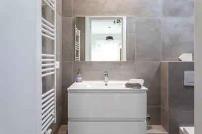 a bathroom with a white sink and a mirror at Beautiful studio in Antwerp