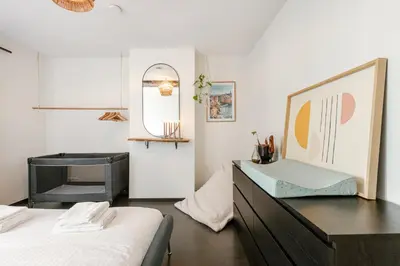 a bedroom with two beds and a dresser and a mirror at Right In The City Center Your Ghent Getaway in Ghent