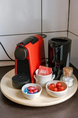 a table with a coffee maker and bowls of tomatoes at Right In The City Center Your Ghent Getaway in Ghent