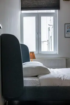a bedroom with two chairs and a bed and a window at Right In The City Center Your Ghent Getaway in Ghent