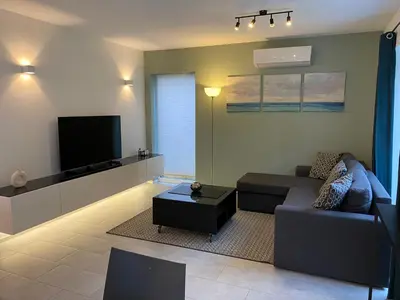 a living room with a couch and a flat screen tv at Bella Vie, rust en ontspanning in Haacht