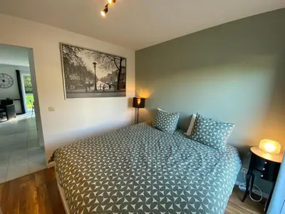 a bedroom with a bed and a picture on the wall at Bella Vie, rust en ontspanning in Haacht