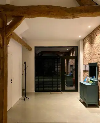 an open hallway with a brick wall and a door at Hoeve De Kleinheide - De Schuur in Dessel
