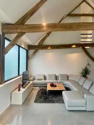 a living room with a couch and a tv at Hoeve De Kleinheide - De Schuur in Dessel