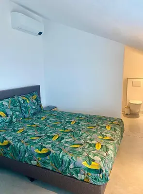 a bedroom with a bed with a colorful bedspread at Hoeve De Kleinheide - De Schuur in Dessel