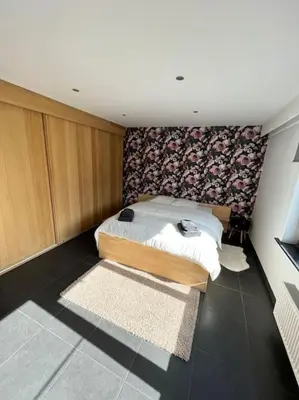 a bedroom with a bed with a flowered wall at Casa Alness in Wetteren