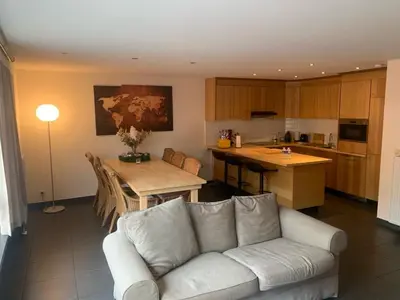 a living room with a couch and a table and a kitchen at Casa Alness in Wetteren