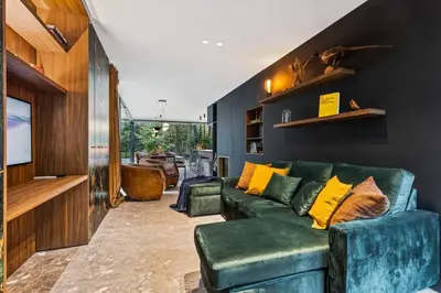 a living room with a green couch and yellow pillows at Stylish lakehouse in idyllic, private green scenery in Stekene