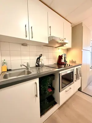 a kitchen with white cabinets and a sink at Heart of Grand Place Beautiful Studio in Brussels