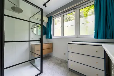 a bathroom with white cabinets and blue curtains at La Louve - Big Place & Garden - Parking Gratuit in Brussels
