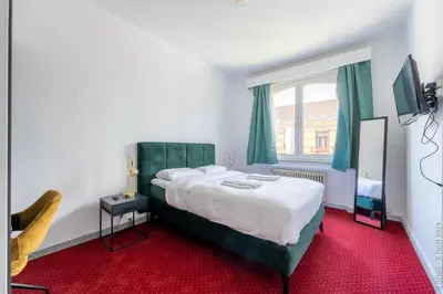 a bedroom with a large bed and a window at La Louve - Big Place & Garden - Parking Gratuit in Brussels