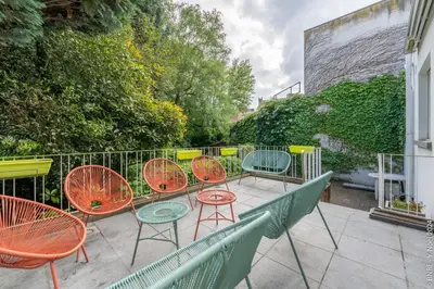 a group of chairs and tables on a patio at La Louve - Big Place & Garden - Parking Gratuit in Brussels