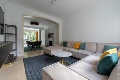 a living room with a couch and a table at La Louve - Big Place & Garden - Parking Gratuit in Brussels