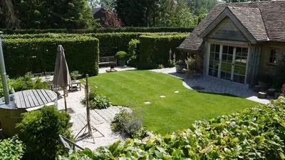 a garden with an umbrella and a lawn at B&B Hemel & Haard in Assenede