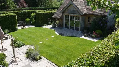 a small garden with a lawn and a bench at B&B Hemel & Haard in Assenede