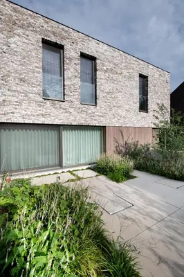a brick building with windows and plants in front of it at Nuit Blanche in Oud-Heverlee