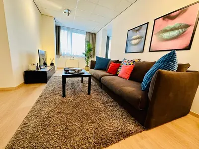 a living room with a brown couch and a table at Urbanstay Suites - Grand Place 2 Bd Penthouse in Brussels