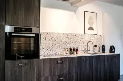 a kitchen with wooden cabinets and a black oven at De verloren hoek in Aarschot