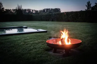 a fire pit sitting in the grass in a yard at De verloren hoek in Aarschot