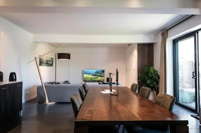 a dining room with a table and chairs and a bed at De verloren hoek in Aarschot