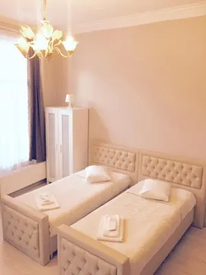 a bedroom with two beds and a chandelier at Prestige Flats in Brussels
