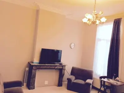 a living room with a tv and two chairs at Prestige Flats in Brussels