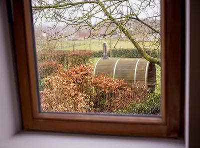 a picture of a barrel in a field of flowers at Maison Raymond - Vakantiehuisje met houtgestookte sauna in Melsen