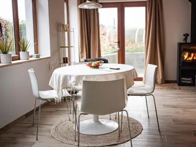 a dining room with a white table and chairs at Maison Raymond - Vakantiehuisje met houtgestookte sauna in Melsen
