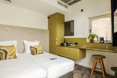 a hotel room with a bed and a desk at Gare 55 in Evergem