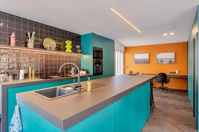 a kitchen with blue and orange walls and a sink at Uma's Urban Lounge in Mechelen