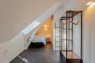 a bedroom with a bed and a stair case at Uma's Urban Lounge in Mechelen
