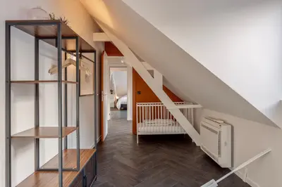 a living room with a staircase and wooden floors at Uma's Urban Lounge in Mechelen
