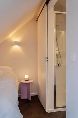 a bedroom with a bed and a glass shower at Uma's Urban Lounge in Mechelen