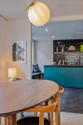 a kitchen with a wooden table and blue cabinets at Uma's Urban Lounge in Mechelen