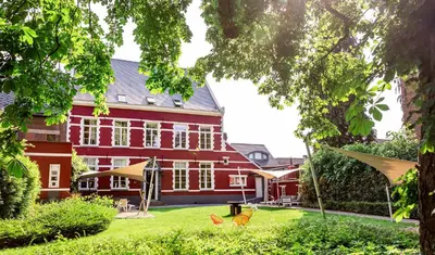 a red building with two rabbits in the yard at De Pastorie Alsemberg B&B in Beersel