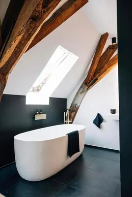 a bathroom with a large white tub in the attic at De Pastorie Alsemberg B&B in Beersel