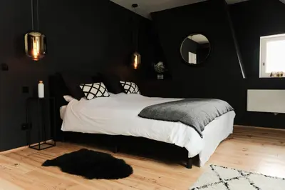 a bedroom with black walls and a bed with a rug at De Pastorie Alsemberg B&B in Beersel