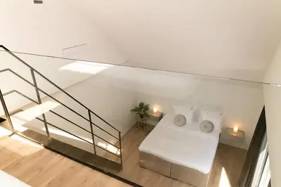 a room with a bed with white sheets and pillows at HVN10 - Near Antwerp in Stabroek
