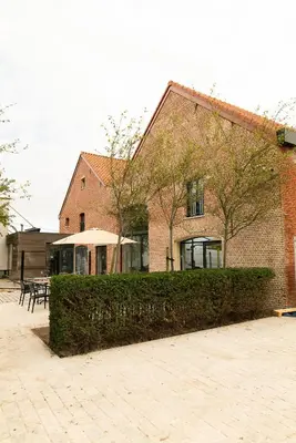 a brick building with a hedge in front of it at HVN10 - Near Antwerp in Stabroek